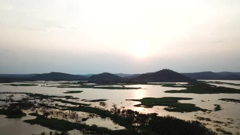 Drone-shot-flying-over-a-river-at-sunset