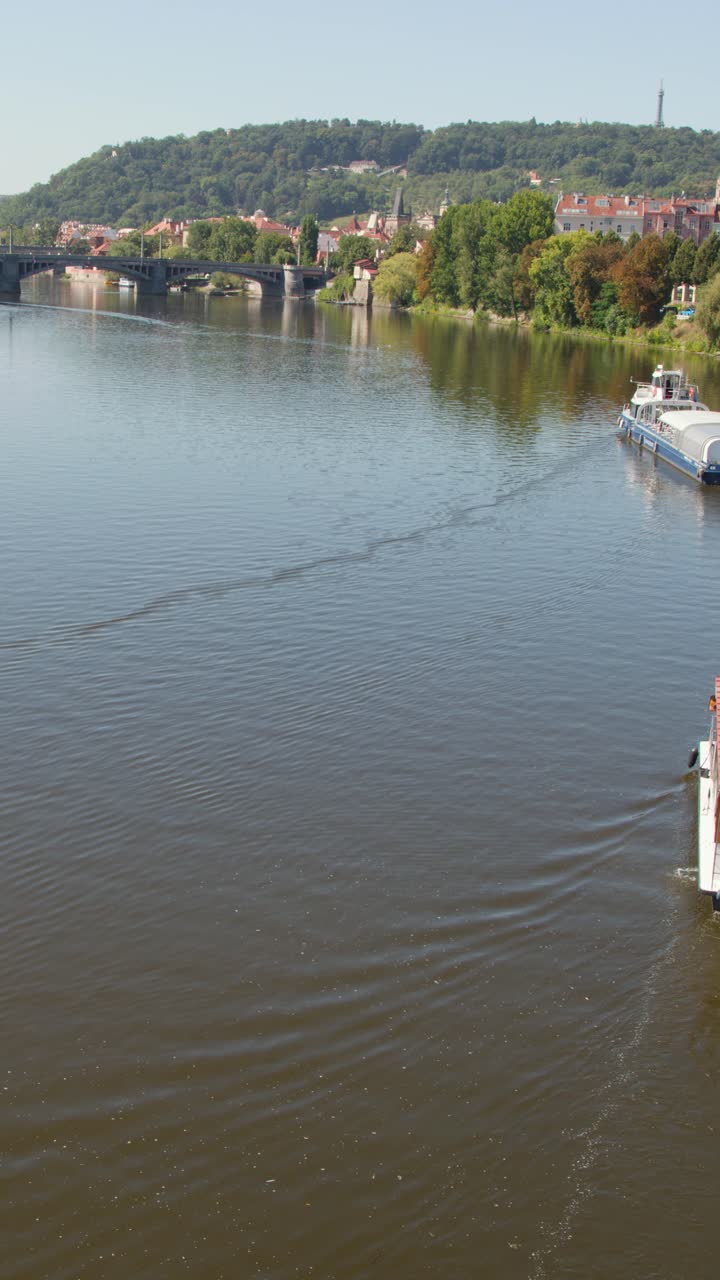 Battello passeggeri scivola sul fiume Moldava, luce diurna estiva, architettura di Praga, prospettiva aerea stabile