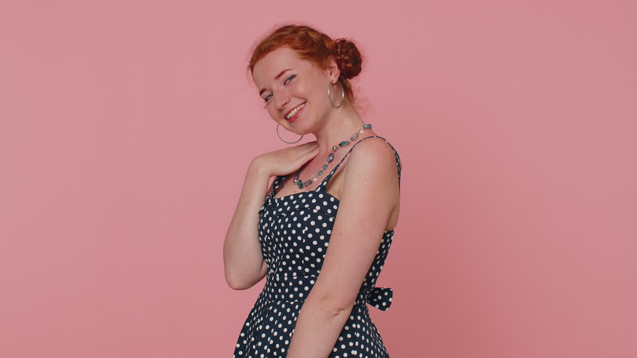 Mulher ruiva sorridente, brincalhona e feliz, piscando o olho, olhando para a câmera com um sorriso, flertando.