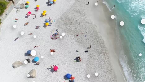 digital composition of multiple white spots floating against aerial view of the beach