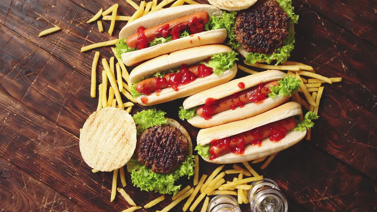 Fastfood assortment  Hamburgers and hot dogs placed on rusty wood table