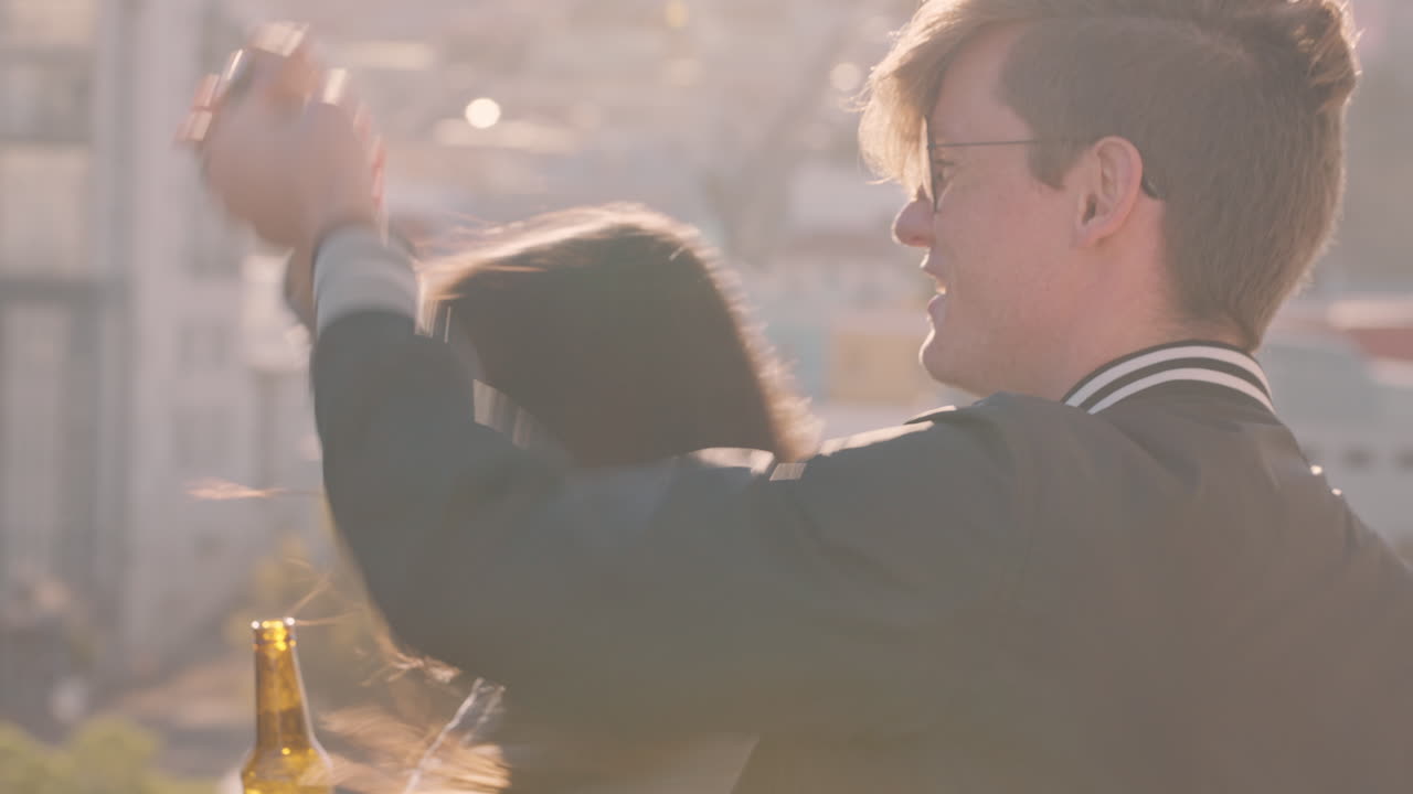 옥상 파티 축하 친구들이 춤추고 여름 휴가를 즐기고 술을 마시고 해가 지는 도시에서  ⁇ 은 주말을 축하합니다.