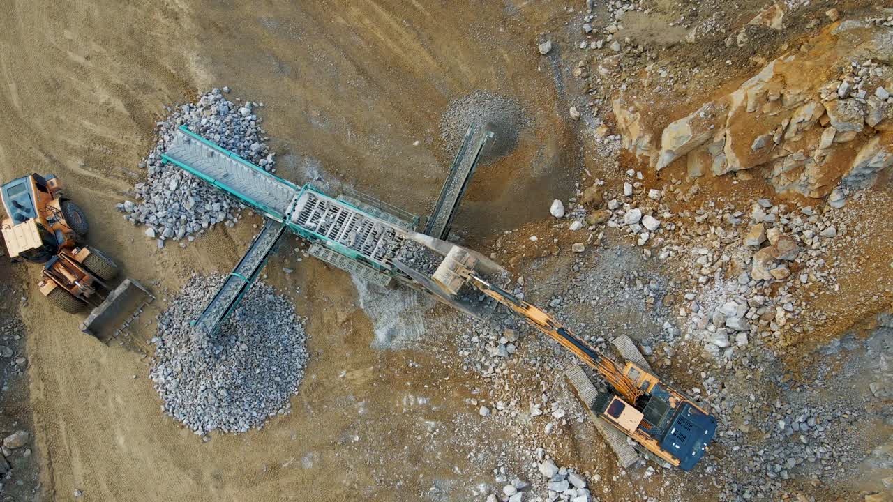 la potencia de la maquinaria pesada: una excavadora, una criba inclinada sobre orugas y una cargadora de ruedas en acción en una cantera