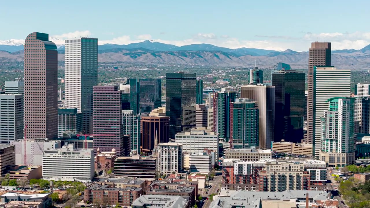 Vista hyperlapse da drone dello skyline di Denver con sfondo montuoso in Colorado.