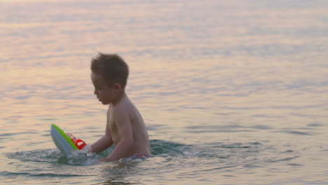 boy playing in the sea at sunset