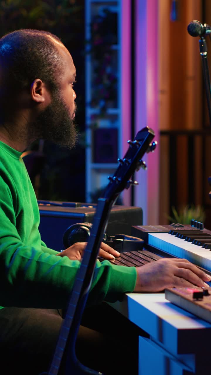 Focused Musician Playing Keyboard and Guitar in Studio