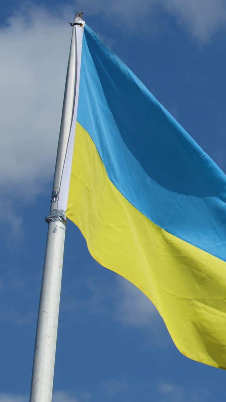 Primo piano verticale della bandiera ucraina blu e gialla che sventola su un'asta.