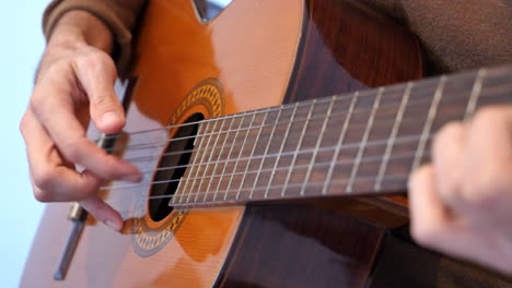 close up of hands playing guitar