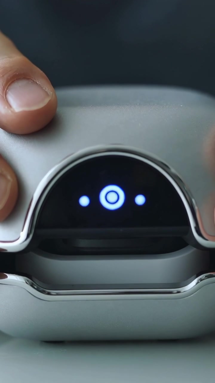 Video verticale: Attivato da un LED blu, mani che sollevano e chiudono una custodia sulla scrivania, ispezionandone l'interno.