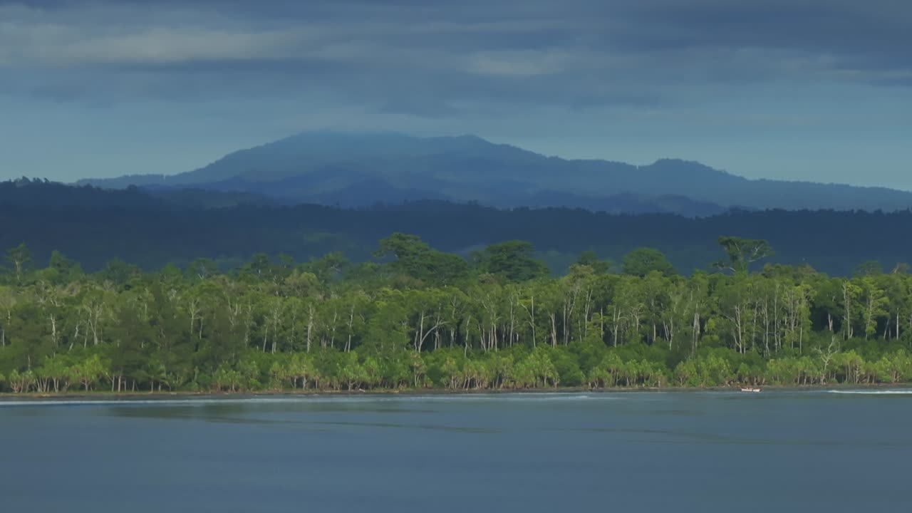 Wewak sea waves pristine beach Wewak Hill Cape Wom Dogreto aerial drone Papua New Guinea Pacific Ocean remote tropical jungle untouched coastline sunny dry season blue sky morning mountain hill static
