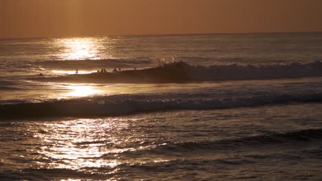 Surfista-Montando-Una-Ola-En-Silueta-Contra-El-Sol-Poniente---Slomo