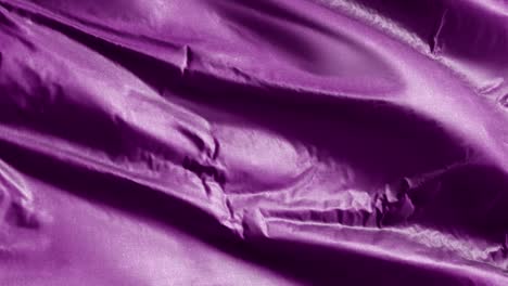 purple textile fabric slow waving on the wind background. solid color tone. full filling slow motion seamless loop.