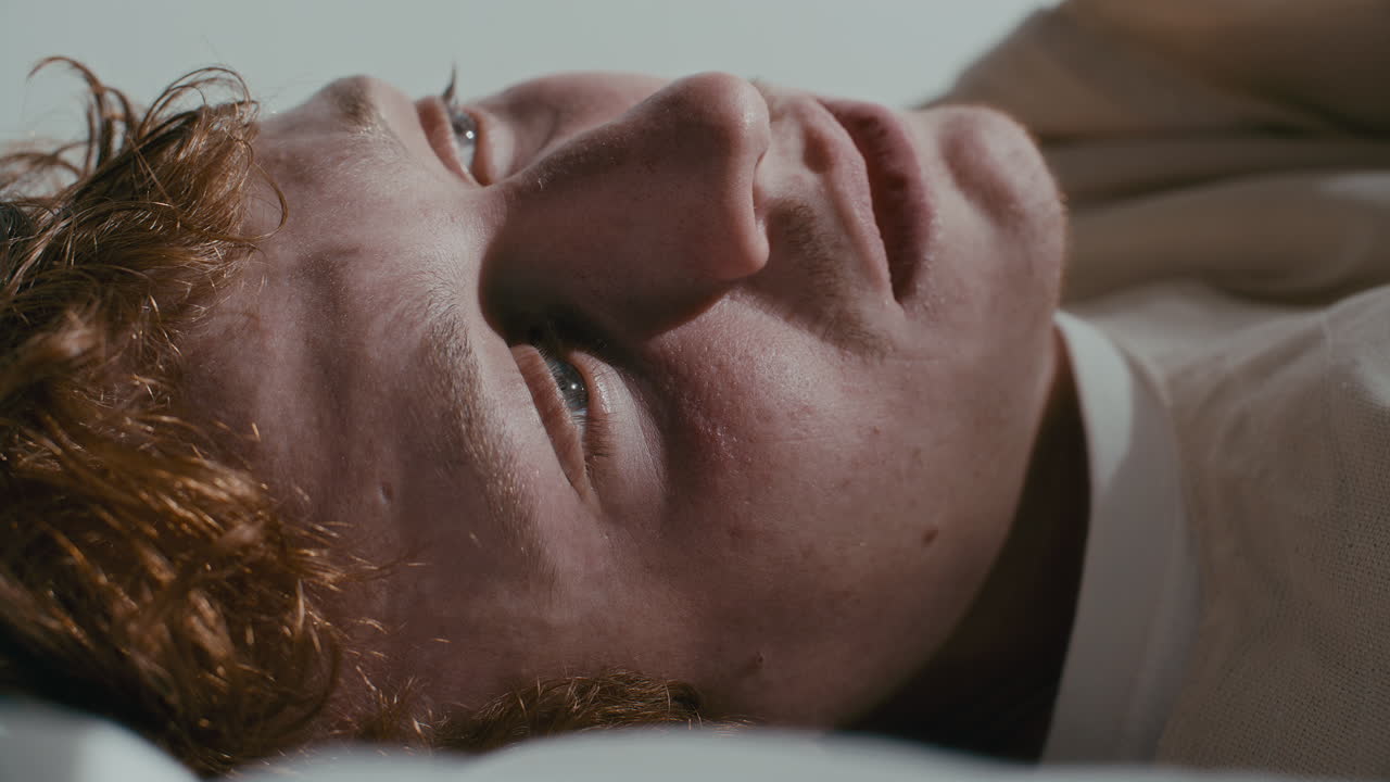 Close Up of Depressed Psychiatric Patient Lying on Hospital Bed