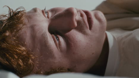 close up of depressed psychiatric patient lying on hospital bed
