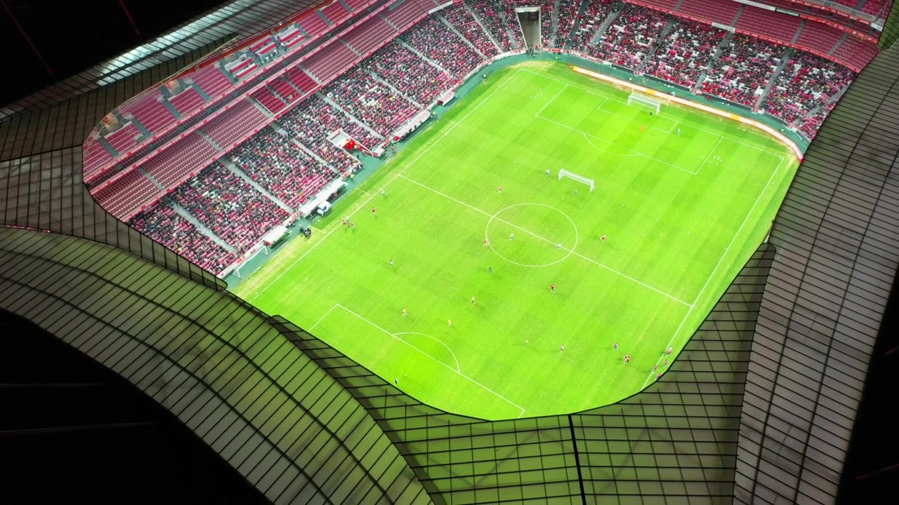 Ripresa aerea, inversa, con drone, che si allontana da una partita su un campo da calcio, all'interno di uno stadio di calcio, di notte, in Portogallo