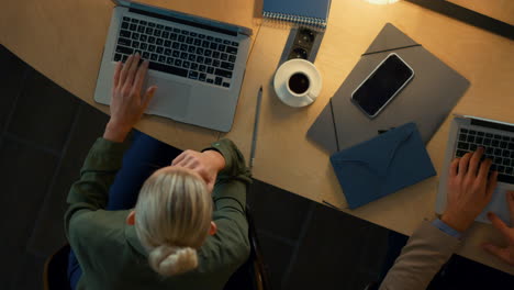 Top-view-lady-working-computer-in-coworking.-Woman-using-laptop-in-dark-space.