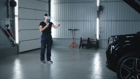 person using a vr headset and controllers in an automotive garage next to a car