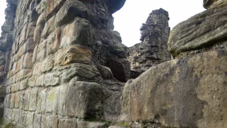 Ancient-Basingwerk-abbey-abandoned-historical-landmark-building-stone-walls-dolly-right-closeup