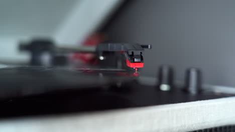 moviendo la cabeza de un tocadiscos para empezar a tocar un vinilo viejo