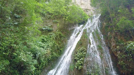 hermosa cascada escénica que cae por la pared alta empinada de la garganta profunda en el parque nacional de wulong, china