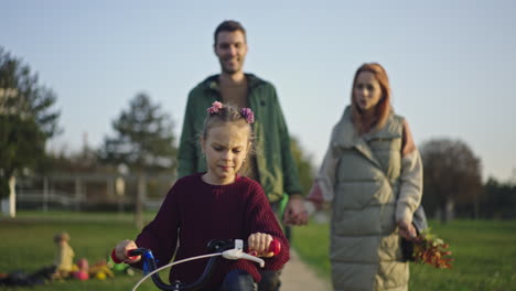 Family riding bikes in the park