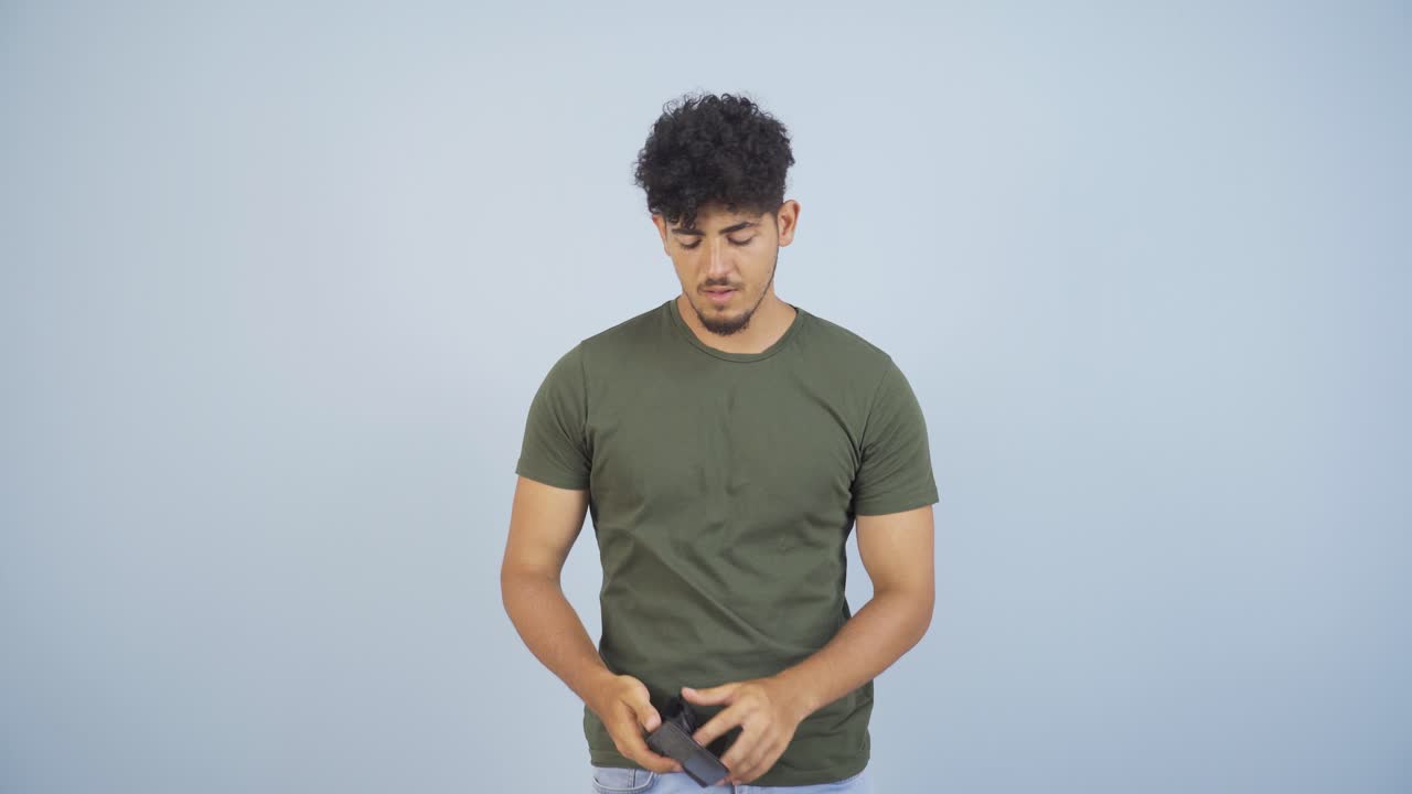 Penniless man looking at his empty wallet.