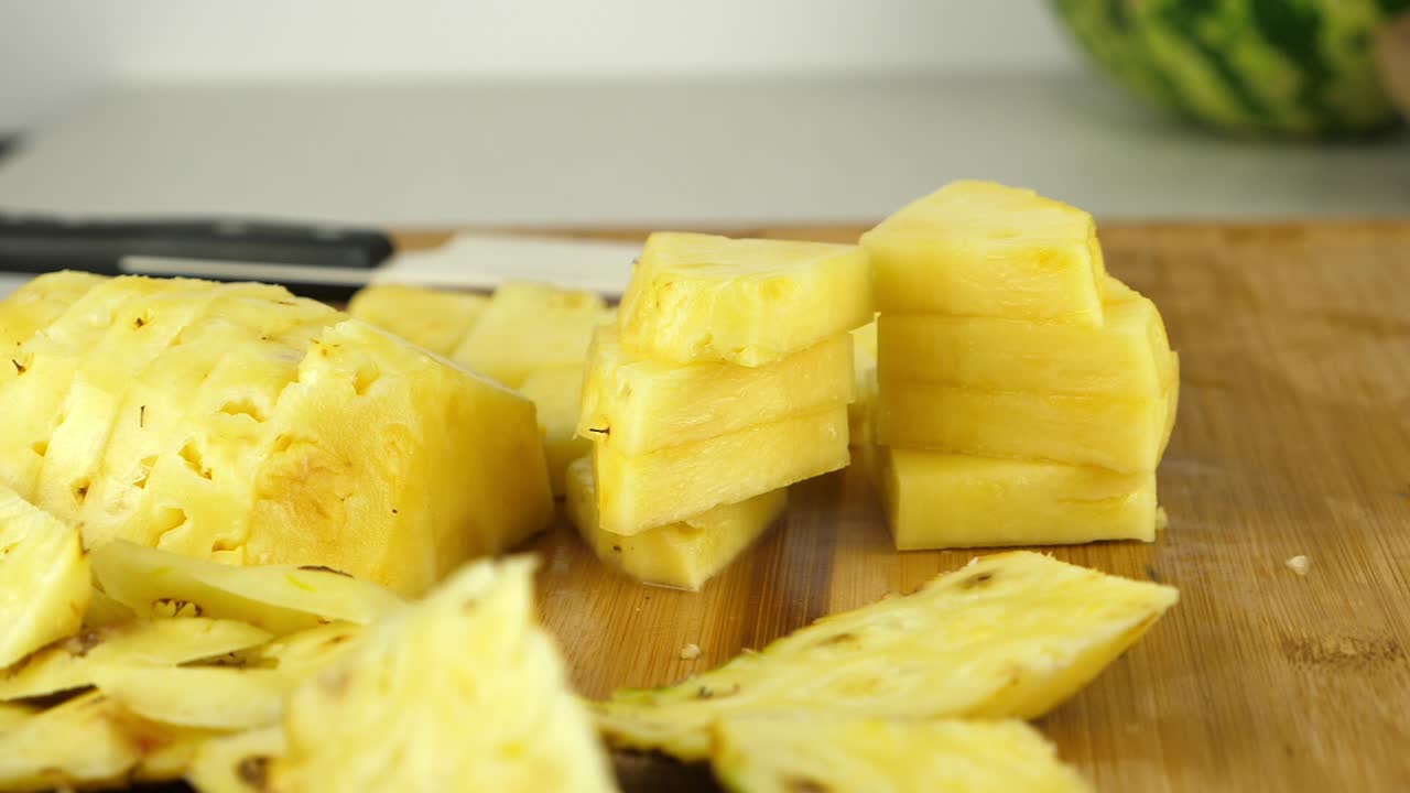 놀랍게 보이는 파인애플 조각의 슬라이더 샷, 방금 다진 것, 배경에 칼
