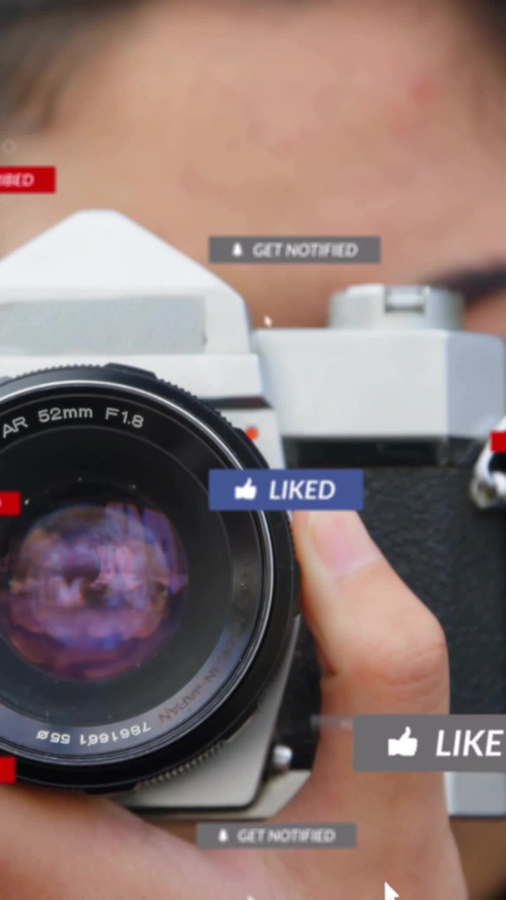 Vertical video: Woman holding SLR cursor tapping LIKE turning LIKED badges around lens raising ROI