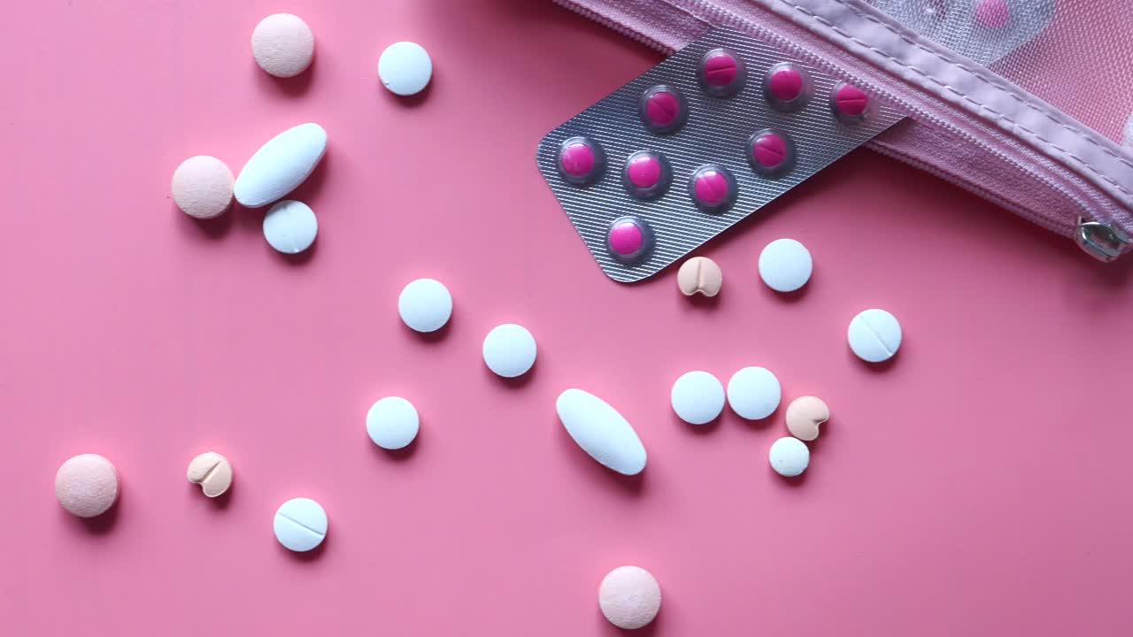 organizador de pastillas rosa con una variedad de medicamentos