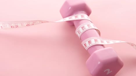 pink dumbbell with measuring tape