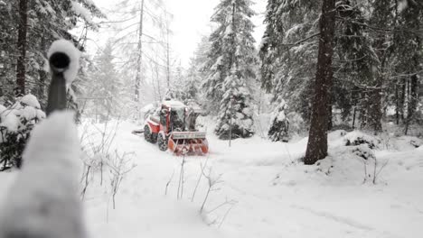 Blick-Auf-Einen-Schneebedeckten-Wald-Und-Eine-Vorbeifahrende-Schneeräumung-In-Kandersteg,-Schweiz