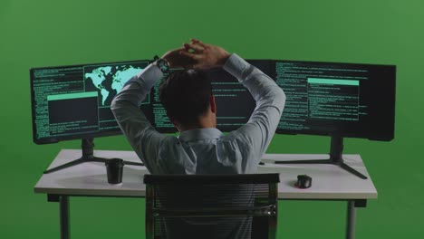 programmer working at a computer with multiple monitors