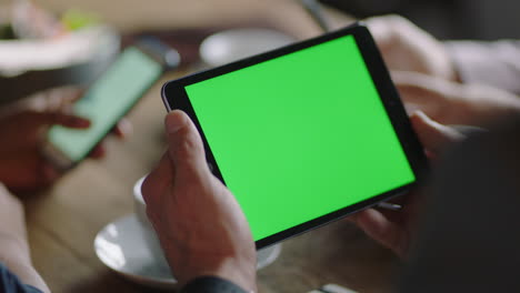 Nahaufnahme-Der-Hände-Eines-Geschäftsmannes-Mit-Einem-Tablet-Computer-Im-Café,-Der-Den-Greenscreen-Auf-Dem-Chroma-Key-Eines-Mobilgeräts-Anschaut-Und-Online-Unterhaltung-Genießt-Und-Social-Media-Werbung-Liest