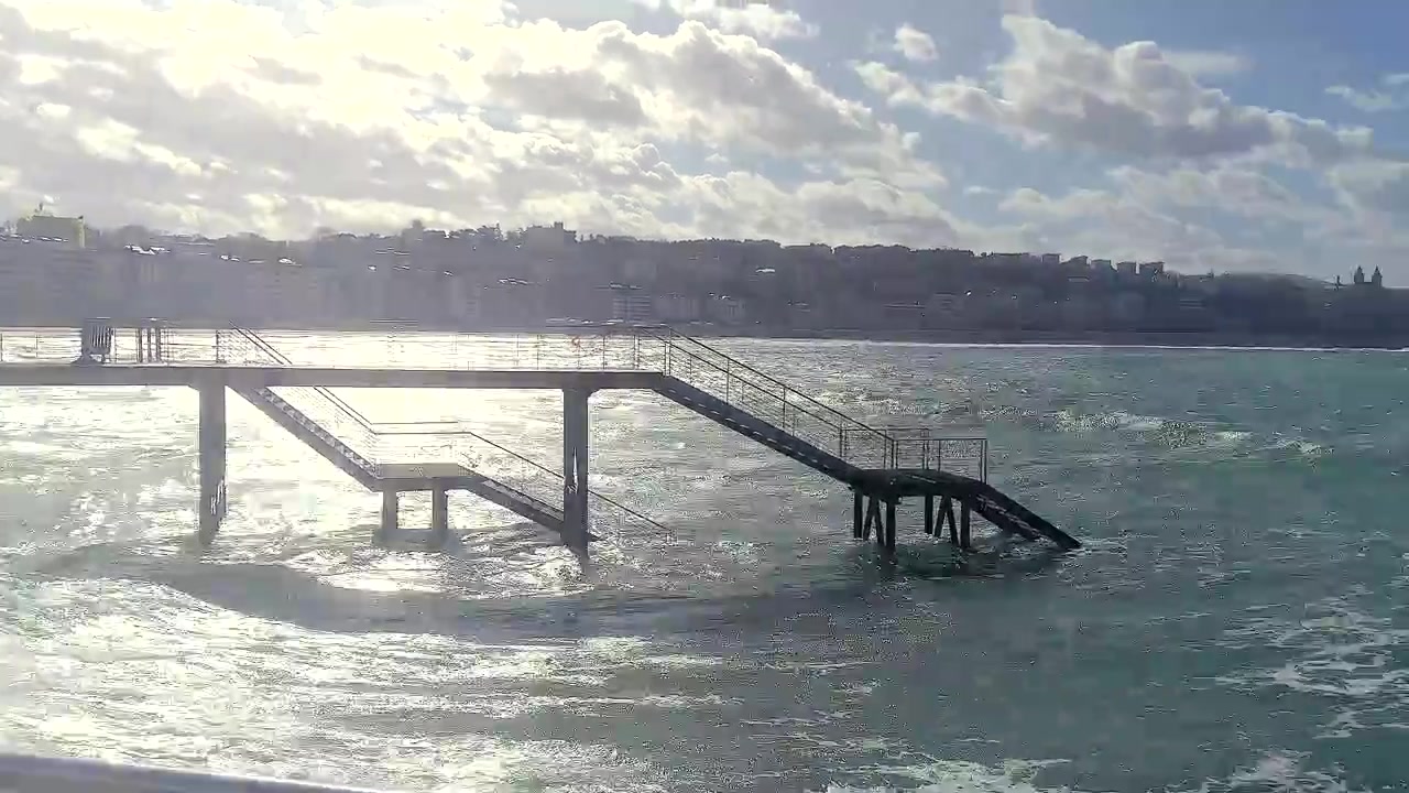Ruční záběr s posunem doprava pláže La Concha s Nauticem a divokými vlnami, San Sebastián, Španělsko.