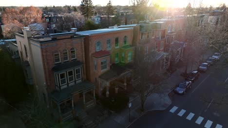 slow aerial approach towards historic brick houses in american city