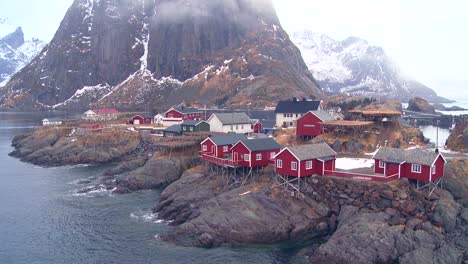 Fog-and-clouds-behind-a-red-fishing-village-in-the-Arctic-Lofoten-Islands-Norway-1