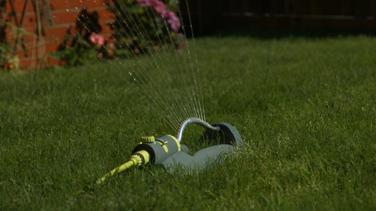 A water sprinkler in a large green garden