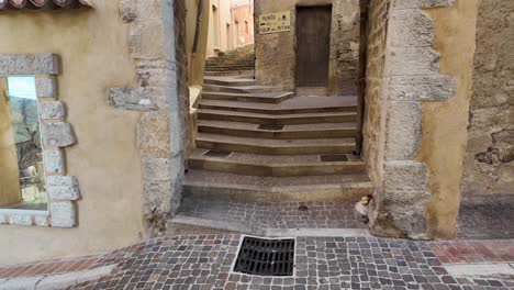 Arched-passageway-and-stoney-staircase,-with-cobbled-street-with-old-stone-houses-in-French-provencal-village