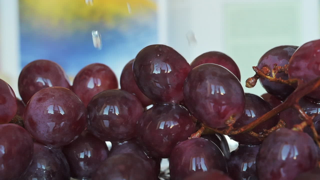 Água derramando sobre uvas vermelhas em uma cozinha