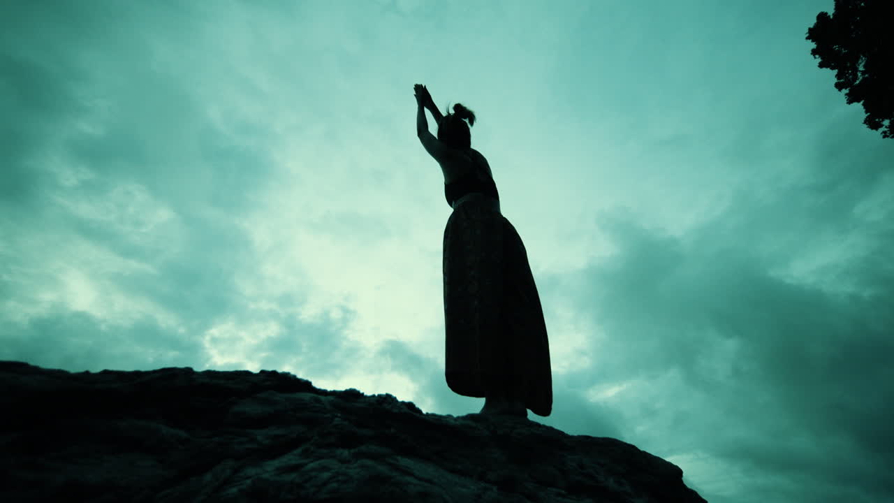 Woman in Yoga Pose on a Rock at Sunset