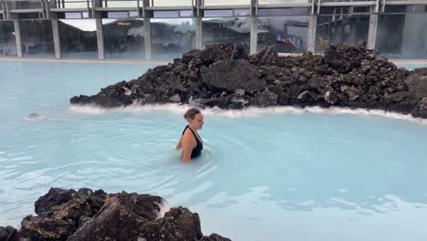 cheerful sweet young woman happily bathing in blue lagoon thermal spa in iceland