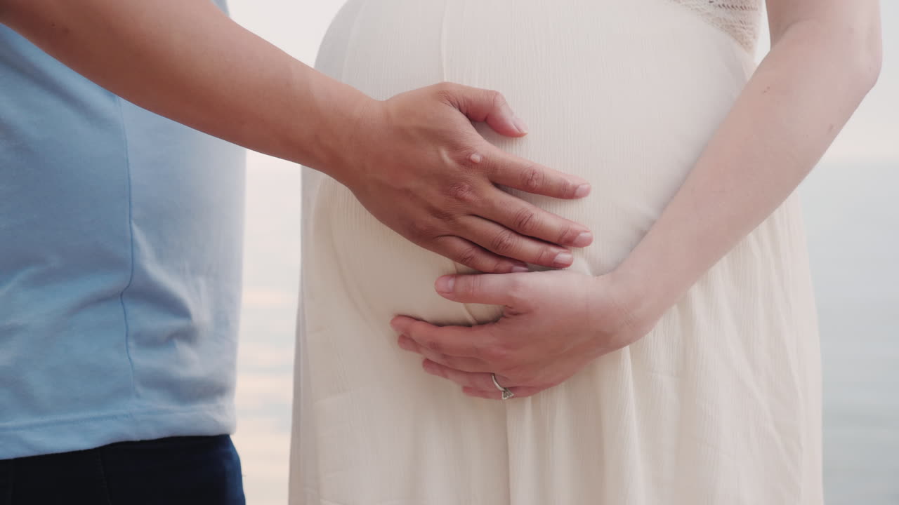 젊은 남자의 손은 임신한 아내 근접 촬영의 손을 잡고