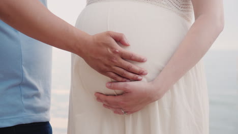 Hands-Of-A-Young-Man-Hold-Hands-Of-His-Pregnant-Wife-Closeup-Shot