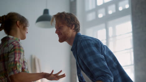 carefree couple bending to each other indoors. family having fun during repair.