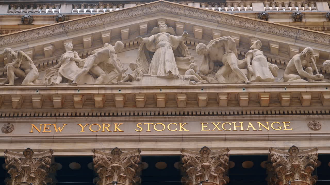 New York, USA, 5 dicembre 2025: Facciata della Borsa di New York con sculture classiche. Primo piano della facciata della Borsa di New York, con le sculture classiche del frontone ricche di dettagli e oro