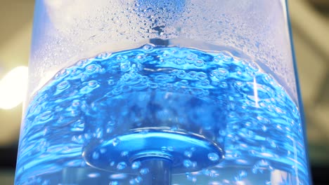 close-up of blue water with bubbles in a dispenser