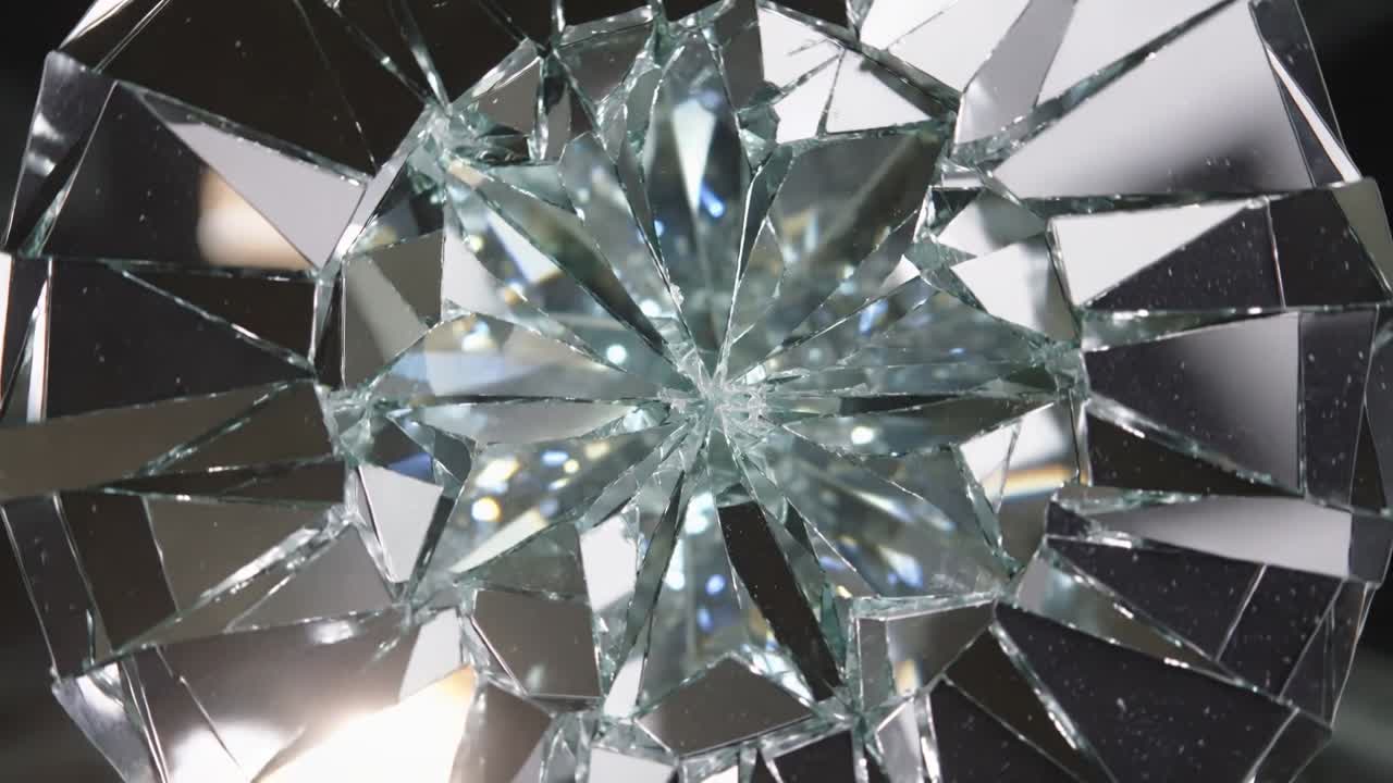 Avslører stjerneformet brudd i herdet glass som fanger glimt mens kamera panorerer i studio med speil.
