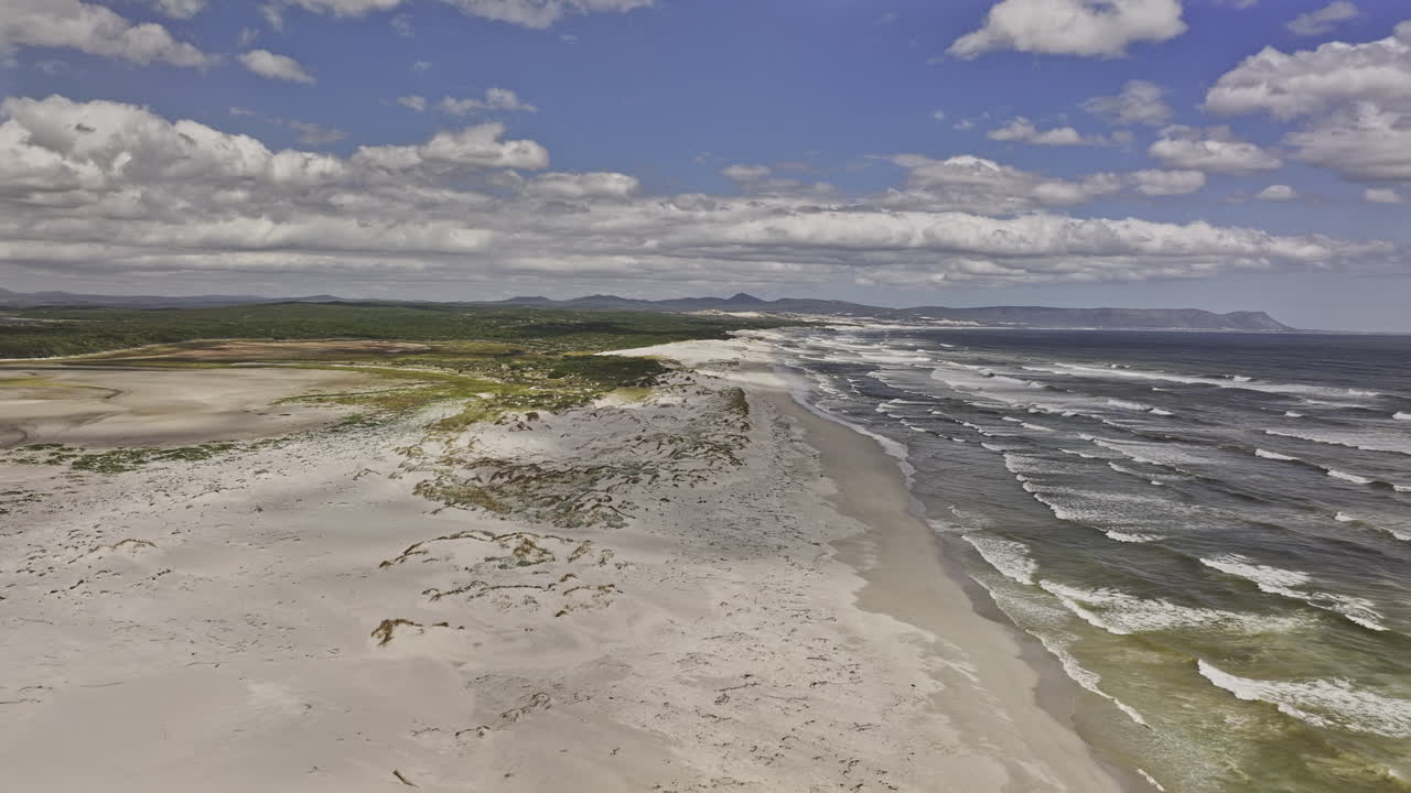 Paesaggio costiero con spiaggia, montagne e nuvole suggestive