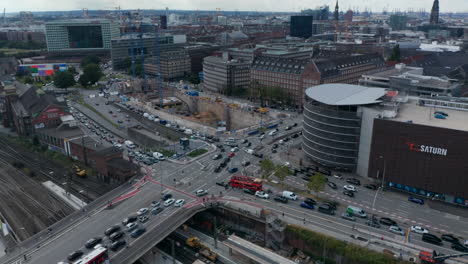 Luftaufnahme-Von-Autos,-Die-Während-Der-Hauptverkehrszeit-Durch-Mehrspurige-Straßenkreuzungen-In-Der-Stadt-Fahren.-Baustelle-Neben-Der-Kreuzung.-Freie-Und-Hansestadt-Hamburg,-Deutschland