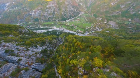 vuelo de proximidad de drones por una montaña hacia el pueblo de theh en albania en otoño